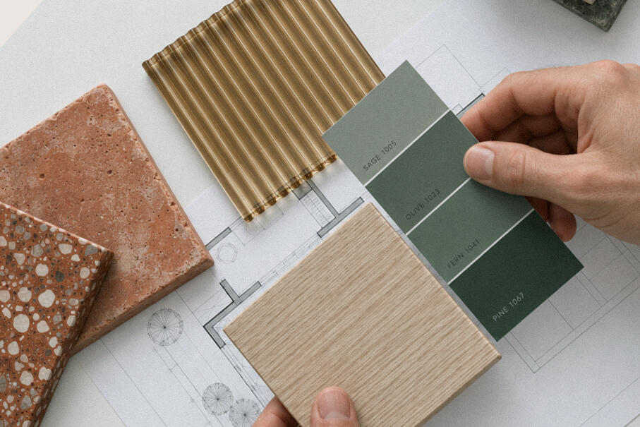 Vue réaliste d'une cuisine avec meubles en bois brulé, crédence en zellige bleu-vert, plan de travail chêne et béton ciré et suspension linéaire en papier japonais.